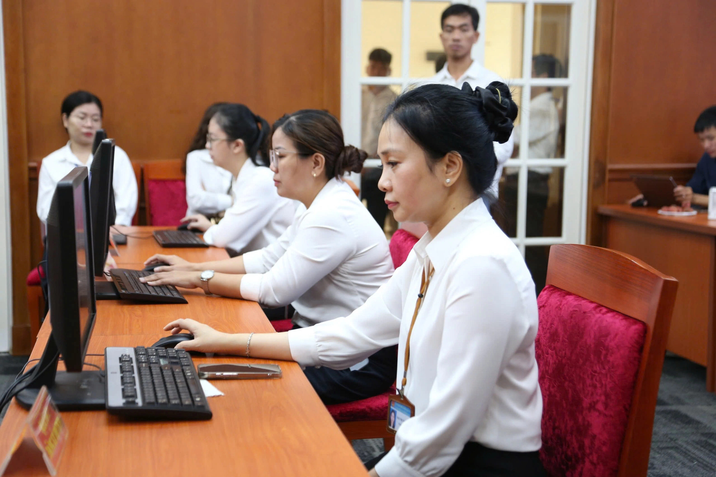 Ảnh: Cán bộ UBND phường tại TP.HCM thao tác xử lý hồ sơ trong ngày đầu triển khai chính quyền hai cấp. Tác giả: Đình Văn.